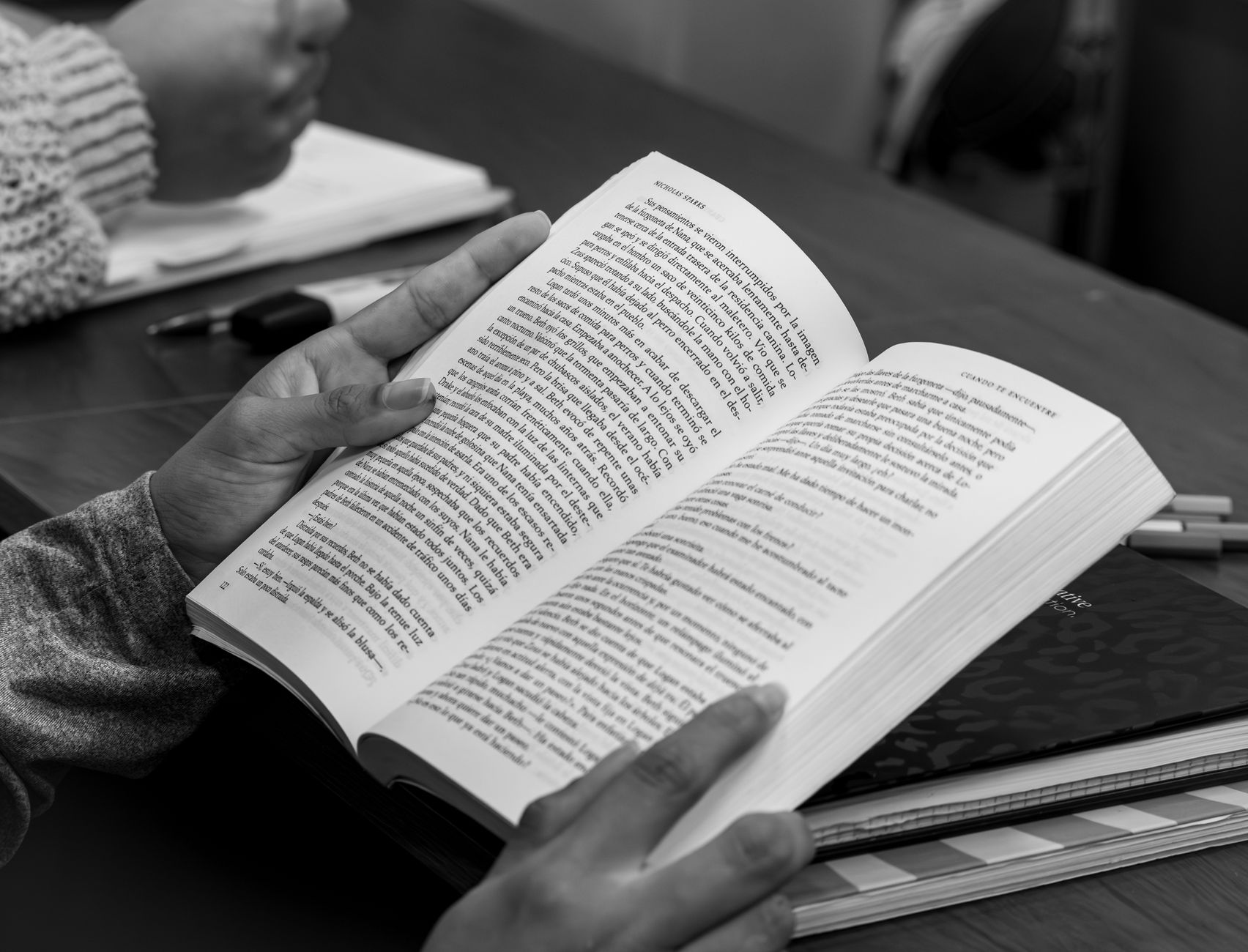 black and white image of hands holding a book